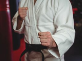 Pessoa vestida com um quimono branco tradicional de jiu jitsu.