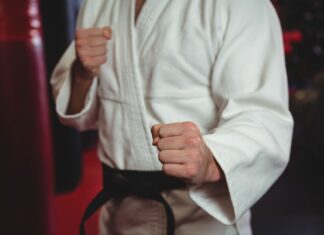 Pessoa vestida com um quimono branco tradicional de jiu jitsu.