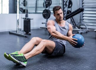 Homem realizando exercícios funcionais com medicine ball.