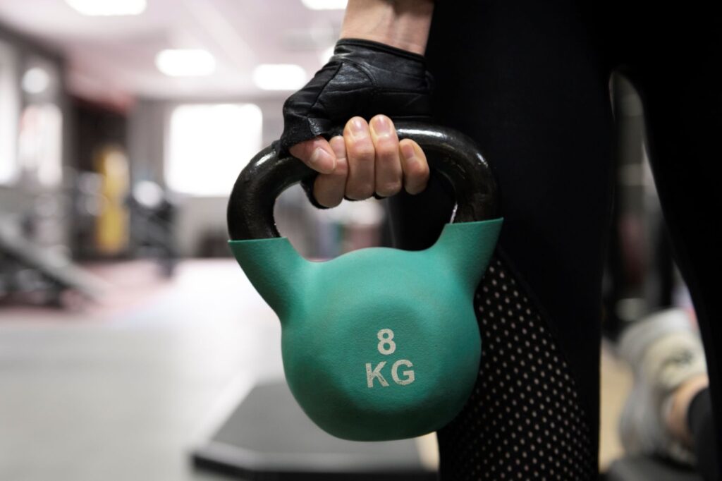 Close de mulher segurando um kettlebell Close de mulher segurando um kettlebell.