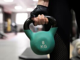 Close de mulher segurando um kettlebell.