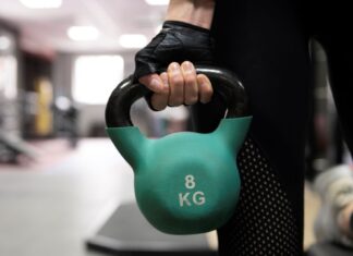 Close de mulher segurando um kettlebell.