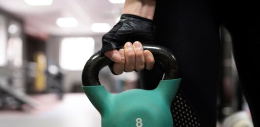 Close de mulher segurando um kettlebell.