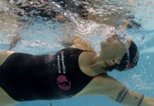 Close de uma mulher praticando natação em uma piscina.