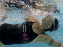Close de uma mulher praticando natação em uma piscina.