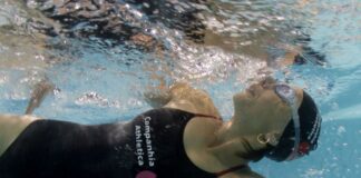 Close de uma mulher praticando natação em uma piscina.