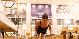 Mulher praticando pilates na Cia Athletica com equipamento.