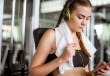 Mulher escutando música enquanto treina na academia.