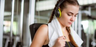 Mulher escutando música enquanto treina na academia.