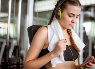 Mulher escutando música enquanto treina na academia.