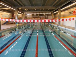 Academia com natação: 10 motivos para combinar os treinos Piscina coberta da Cia Athletica, com raias demarcadas por boias vermelhas, pretas e brancas, prontas para treinos de natação.