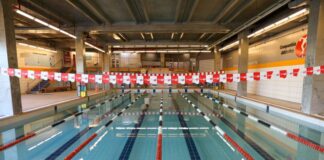 Academia com natação: 10 motivos para combinar os treinos Piscina coberta da Cia Athletica, com raias demarcadas por boias vermelhas, pretas e brancas, prontas para treinos de natação.