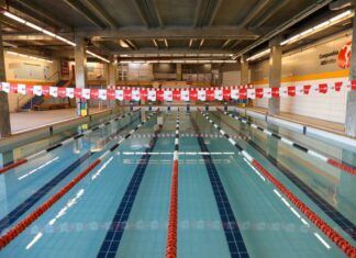 Academia com natação: 10 motivos para combinar os treinos Piscina coberta da Cia Athletica, com raias demarcadas por boias vermelhas, pretas e brancas, prontas para treinos de natação.