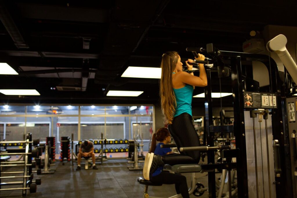 Mulher praticando exercícios para definição muscular em uma academia Mulher praticando exercícios para definição muscular em uma academia.
