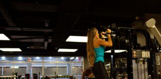 Mulher praticando exercícios para definição muscular em uma academia.