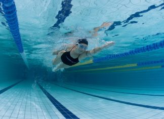 Você já considerou fazer aula de natação? Além de ser uma atividade revigorante, também é um excelente exercício físico para colocar a saúde em dia. Além disso, a prática é indicada para todos os tipos de pessoas de todas as idades, por conta dos efeitos que a água proporciona para o corpo. Então, quer saber mais sobre natação? Acompanhe este conteúdo! Orientações sobre natação Para receber um plano de aula de natação, em primeiro lugar, você precisará passar por uma avaliação com o professor, e também deve realizar um exame médico. Apesar da natação ser uma atividade de baixo impacto, algumas pessoas devem tomar cuidado. Por exemplo, pessoas que têm alergias de pele podem ficar com a pele mais irritada, por causa dos produtos que colocam para a limpeza da piscina. Quem também sofre de graves problemas na coluna, deve procurar outra atividade física. Isso porque a prática exige muita força dos músculos posteriores. Pessoas que têm alguma infecção pulmonar, como bronquite, ou problemas respiratórios, como sinusite, podem ter alguma dificuldade para acompanhar a aula. Por isso, é essencial que tenha autorização do seu médico. Como é uma aula de natação? Antes e depois das aulas, é ideal que você realize alongamentos para aquecer o corpo, mas, dentro d’água. Isso vai aumentar o fluxo sanguíneo que vai para os músculos e lubrificar as articulações. Portanto, você deve nadar de forma suave, por uns 10 minutos, e realizar exercícios de alongamento. Enfim, a aula de natação para iniciantes é uma excelente forma de começar a praticar a atividade física. Se você ainda não sabe nadar, ou se não conhece as técnicas de nado, vai aprender isso nas aulas, conforme for subindo de nível de classe. Mas, se você já sabe nadar e conhece as técnicas, pode fazer aula para aprimorar suas habilidades. Além disso, você pode realizar aulas livres, apenas para praticar o que já aprendeu. Na Cia Athletica, chamamos de Natação Flex Time. Essa modalidade permite que você nada a qualquer hora do dia, em qualquer dia da semana. Também não precisa fazer esta aula com outros alunos, pode nadar sozinho na raia. Contudo, você ainda terá o acompanhamento de um professor, para qualquer dúvida que tiver.
