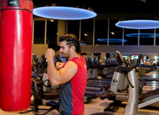 Quando se trata de saber quanto tempo demora para ganhar massa muscular, muitas pessoas ficam ansiosas para obter resultados rápidos. Mas é preciso compreender que a construção de músculos requer tempo, dedicação e um plano adequado de treinamento e nutrição, além disso, varia de pessoa para pessoa, como genética, idade e gênero. Leia mais no post a seguir. Quanto tempo demora para começar a ganhar massa muscular? Antes de falarmos sobre o tempo necessário para ganhar massa muscular, é importante entender como o processo ocorre. Ao fazer um treinamento de força adequado e regularmente, seu corpo passa por um processo chamado hipertrofia muscular. Isso envolve a estimulação das fibras musculares, causando microlesões. Posteriormente, o corpo se recupera e reconstrói essas fibras, levando ao crescimento muscular. A hipertrofia acontece por meio de processos conhecidos como catabolismo, anabolismo e supercompensação. Quando os músculos recebem sobrecarga, eles perdem substâncias que compõem a sua estrutura. São várias substâncias, entre elas água, glicogênio e proteínas de vários tipos. Então, durante o seu treino essa depleção de substâncias se chama catabolismo. Então, após o treino, o próprio organismo começa repor todas essas substâncias. É a fase conhecida por anabolismo. Para que o corpo reponha tudo, é preciso ter uma boa alimentação, descanso, recuperação e sono.