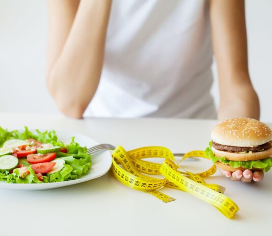 Mulher escolhe entre salada ou hambúrguer para potencializar déficit calórico