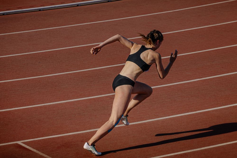 Mulher correndo em pista de corrida.