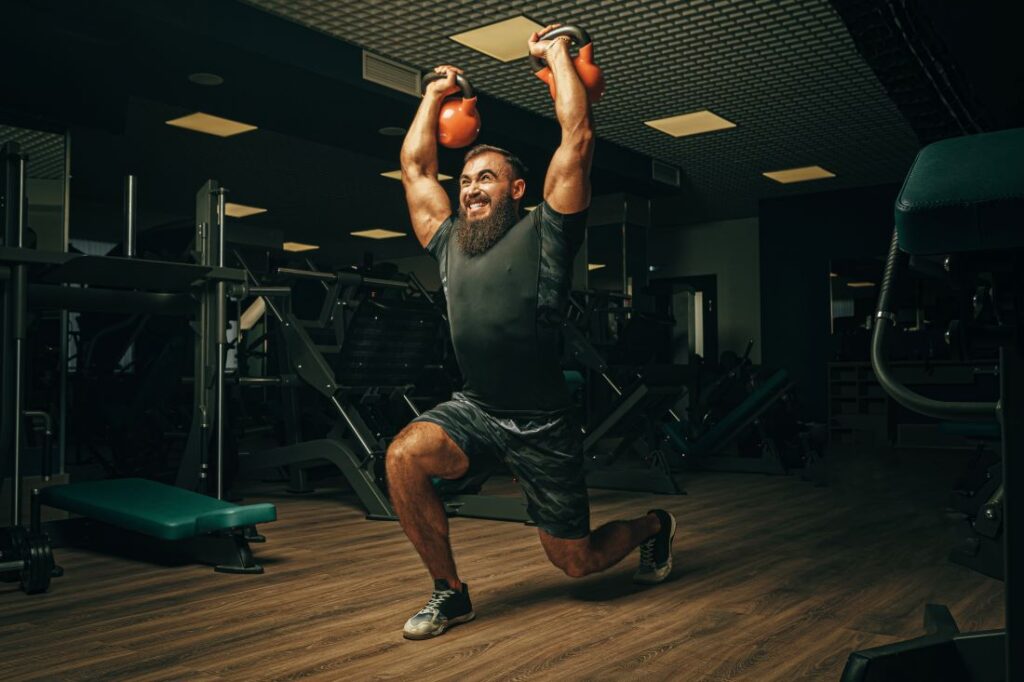 Homem realizando exercício avanço (lunge) com kettlebell.