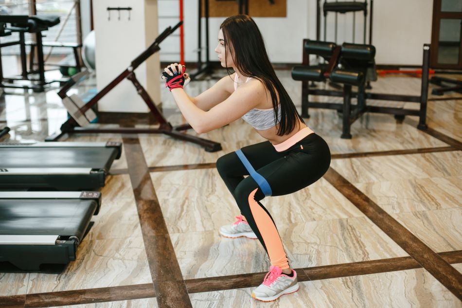 Mulher realizando exercício agachamento.