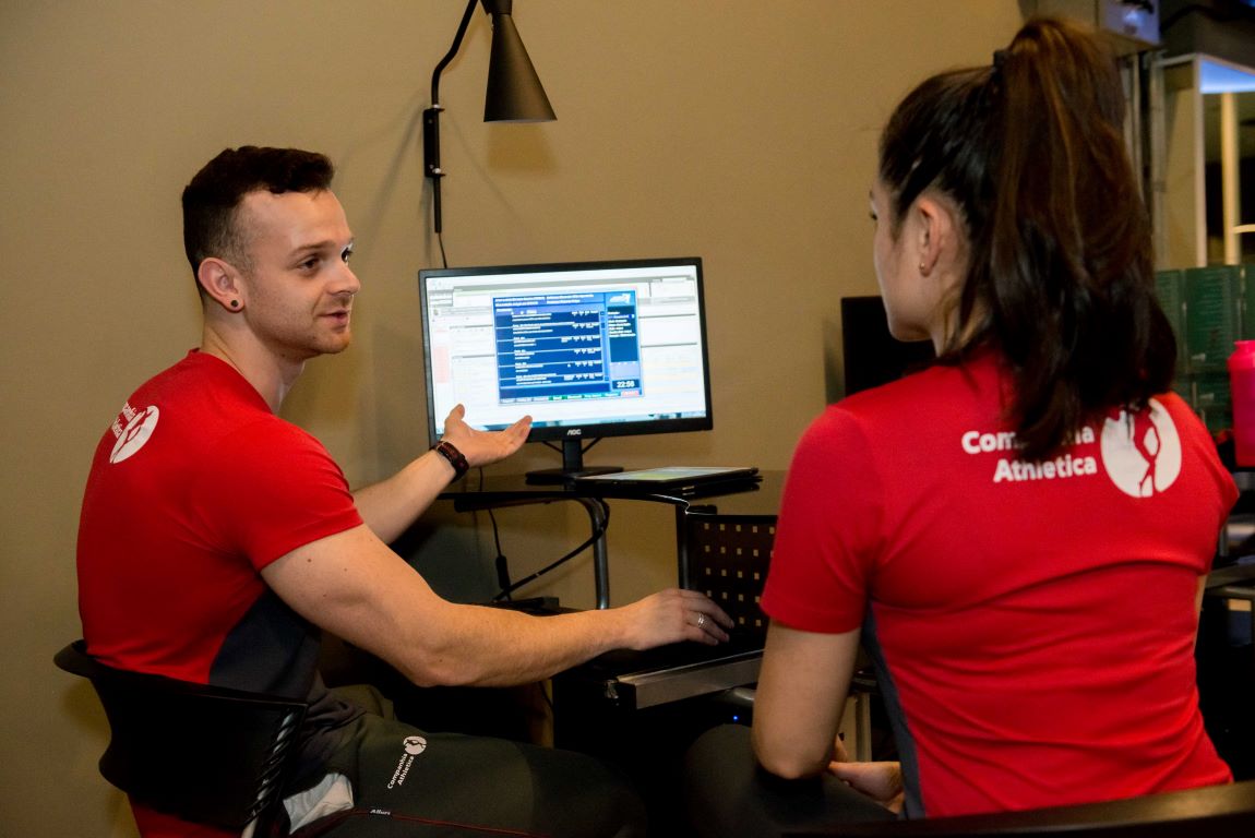 Homem e mulher sentados discutindo sobre como montar treino de musculação.