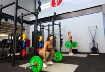 Mulheres levantando barra com anilhas para fazer exercício de levantamento terra.