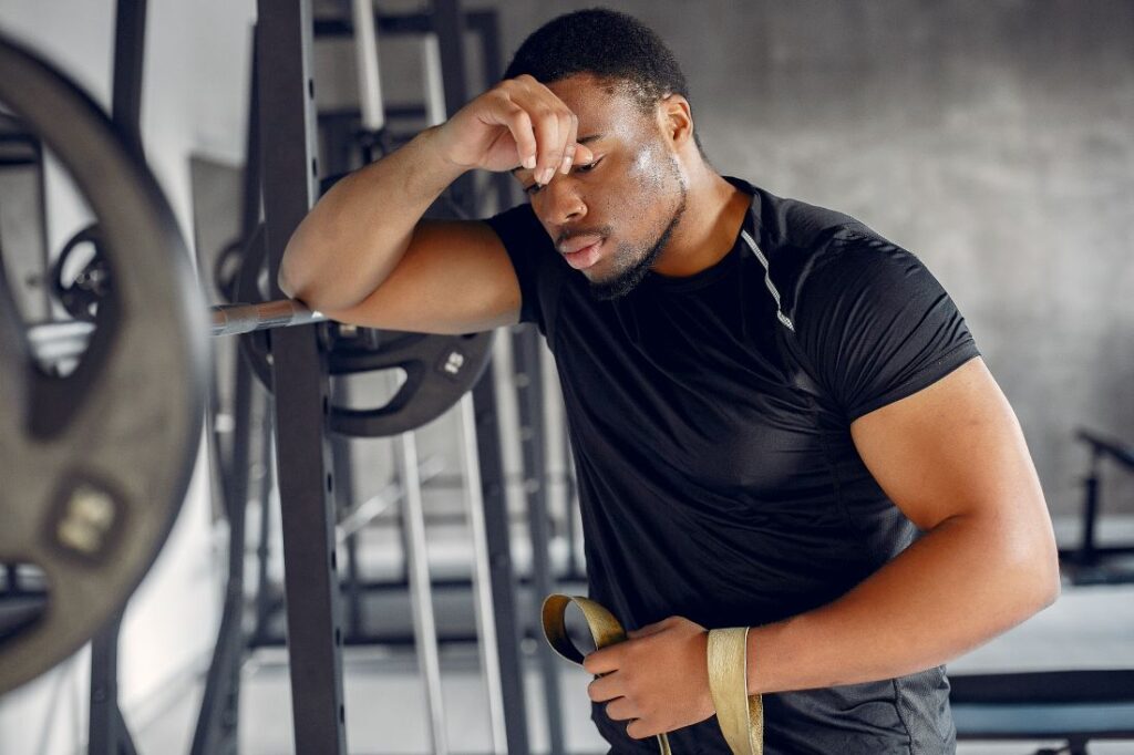 Homem cansado de praticar musculação Homem cansado de praticar musculação.
