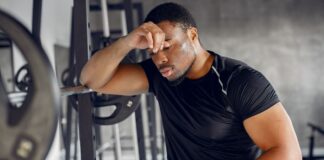 Homem cansado de praticar musculação.