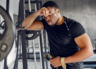 Homem cansado de praticar musculação.
