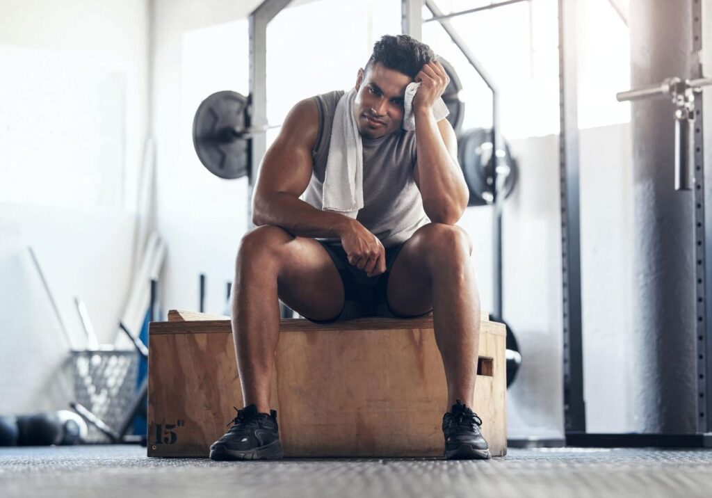 Homem na academia frustrado com seus treinos para musculação Homem na academia frustrado com seus treinos para musculação.