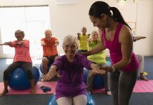 Idosos praticando pilates com bola em grupo, promovendo equilíbrio, mobilidade e bem-estar na terceira idade com acompanhamento profissional.