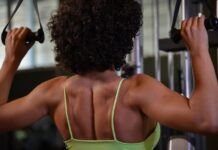 Mulher praticando musculação para as costas na academia.