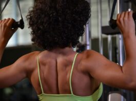 Mulher praticando musculação para as costas na academia.