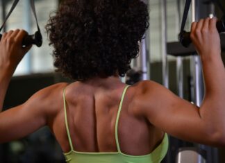 Mulher praticando musculação para as costas na academia.