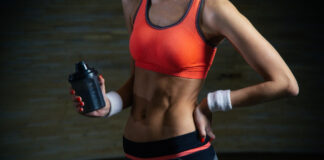 Antes de usar termogênico, entenda os riscos, benefícios e como potencializar os resultados com treino Pessoa treinando, com abdômen em destaque e segurando uma garrafa shaker, representando preparo físico e o uso consciente de suplementos termogênicos aliado ao treino.