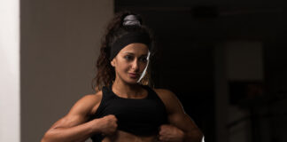 Mulher atleta exibindo definição muscular abdominal na academia, ilustrando fase de bulking e ganho de massa muscular.