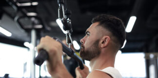 Atleta executando pulley pronado em equipamento profissional de academia - treino de costas