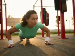 Mulher faz flexão de braços em treino funcional ao ar livre