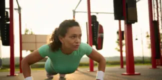 Mulher faz flexão de braços em treino funcional ao ar livre