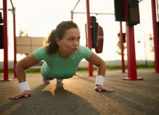 Mulher faz flexão de braços em treino funcional ao ar livre