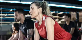 Alunos praticando spinning em academia moderna, com foco e intensidade durante treino coletivo, mesmo em rotina agitada.