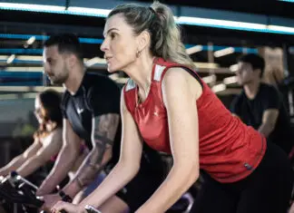 Alunos praticando spinning em academia moderna, com foco e intensidade durante treino coletivo, mesmo em rotina agitada.