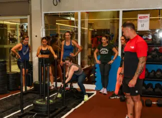 Alunos realizam treino de força em academia com acompanhamento de um profissional da Cia Athletica.