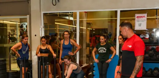 Alunos realizam treino de força em academia com acompanhamento de um profissional da Cia Athletica.