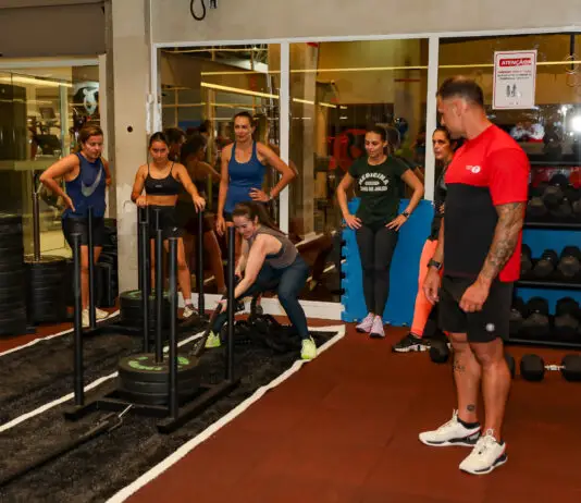 Alunos realizam treino de força em academia com acompanhamento de um profissional da Cia Athletica.